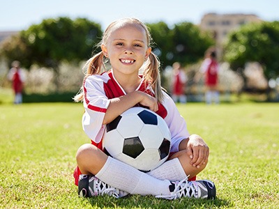 Smiling child holding soccer ball