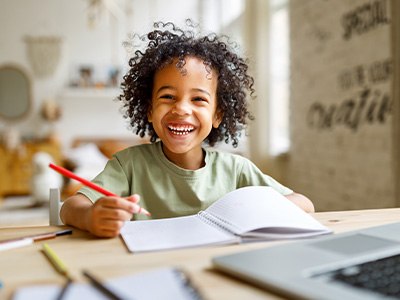 Child smiling while working on homework