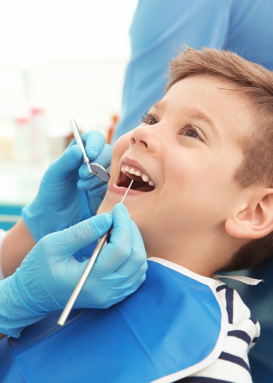 a little boy having his teeth examined