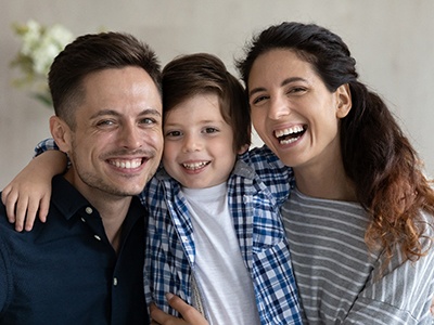 Parents smiling while hugging son