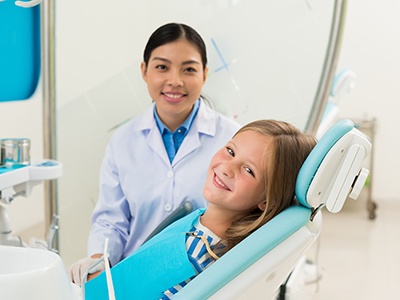 Happy, smiling young girl in dental treatment chair