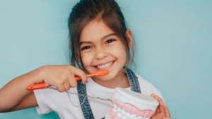 Little girl pretending to brush her smile with dental toy