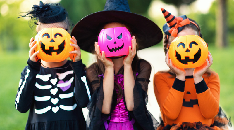 Children with Halloween candy buckets